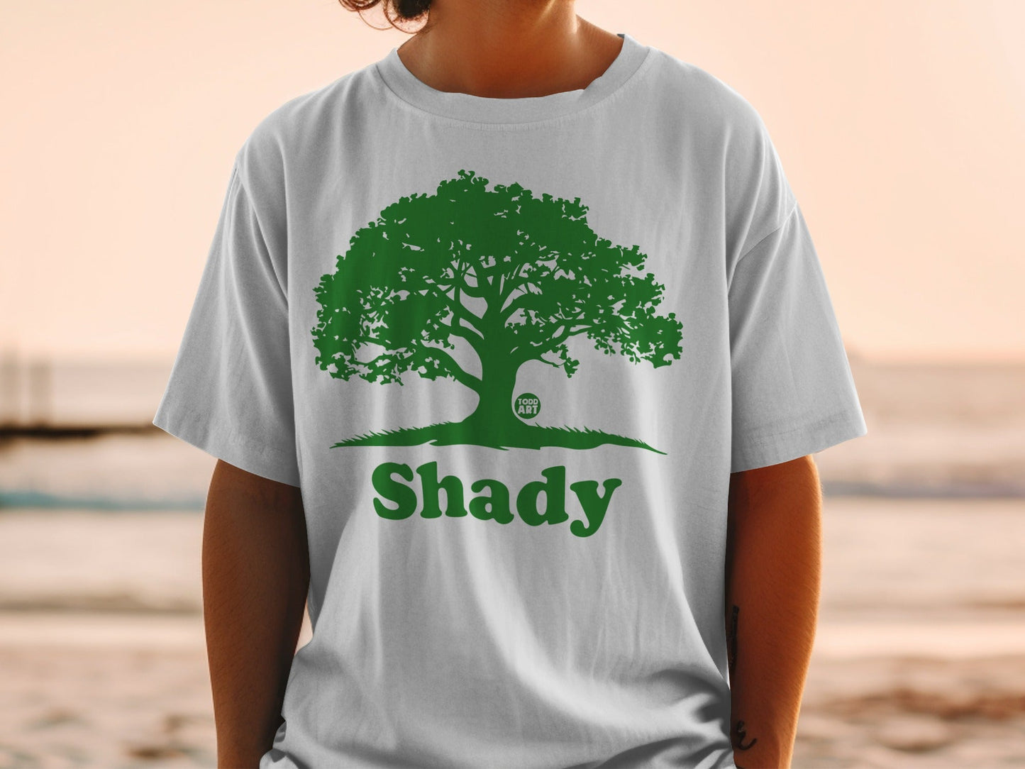 White t-shirt with a green tree logo and the word "Shady".