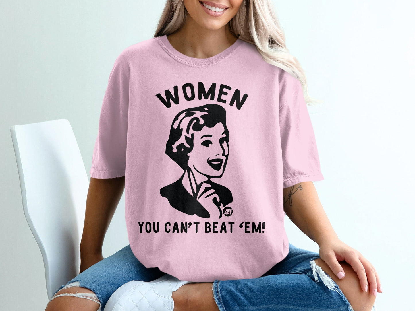 Pink t-shirt with graphic "WOMEN YOU CAN'T BEAT 'EM!".