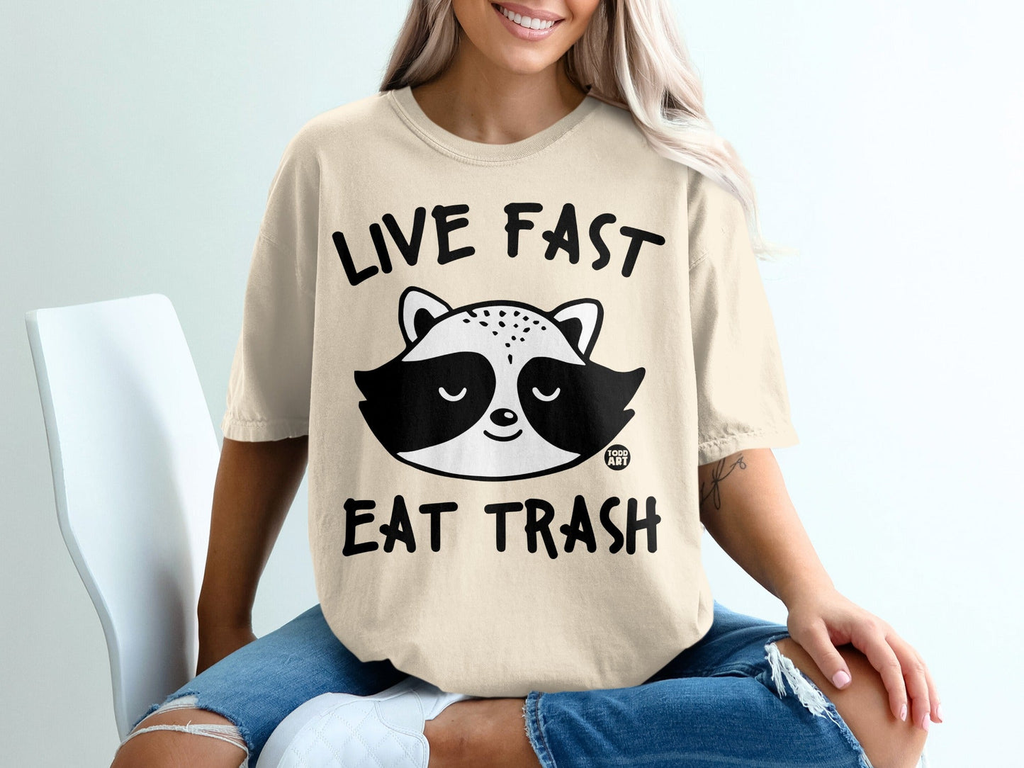 T-shirt with raccoon graphic and text "LIVE FAST EAT TRASH".