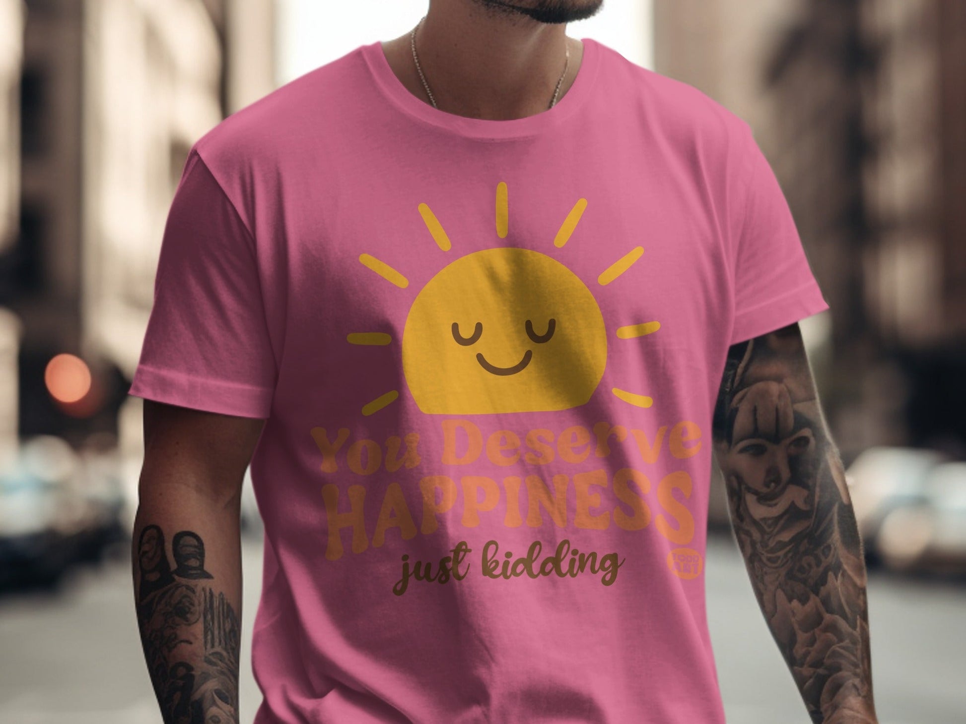 Pink t-shirt with a smiling sun and "You Deserve Happiness just kidding" text.