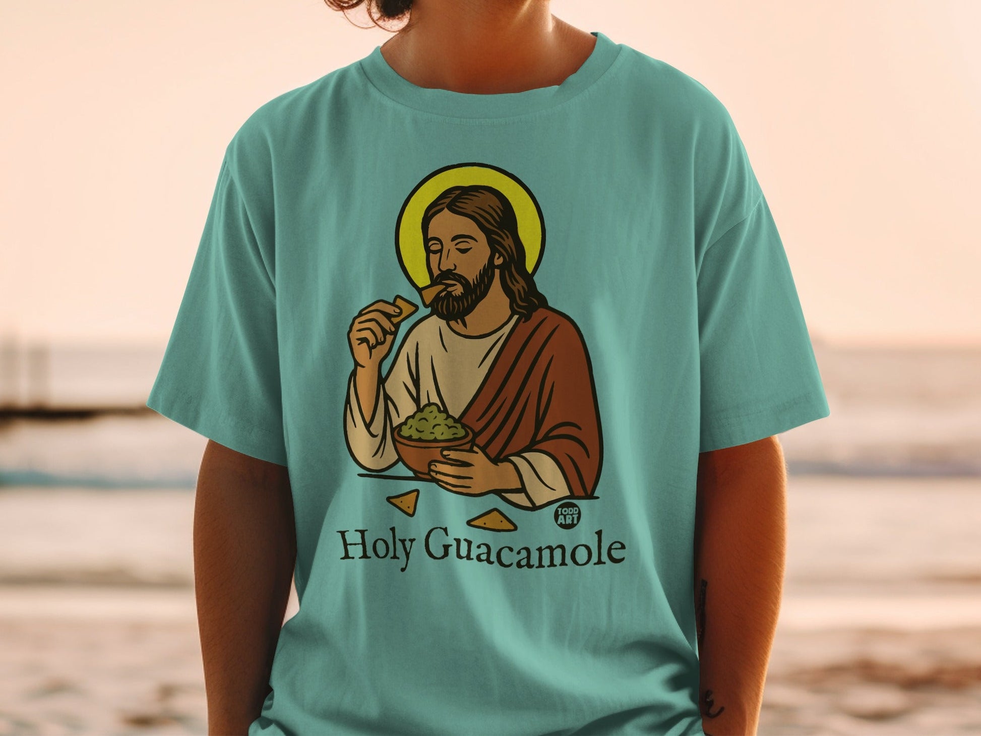 Jesus eating guacamole with tortilla chips, on a light blue t-shirt.