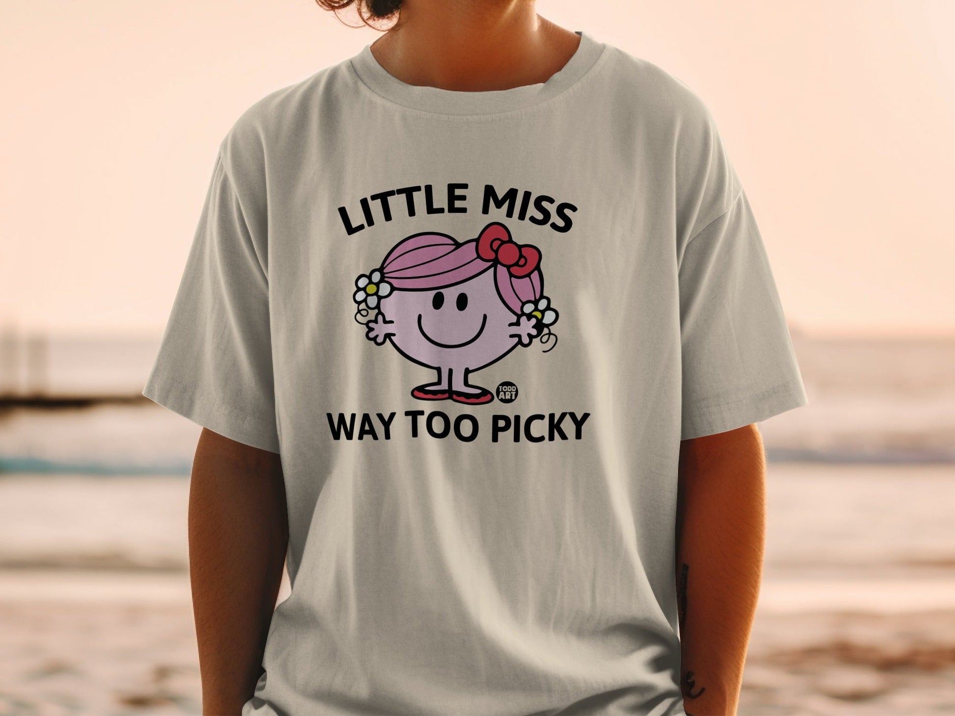 Little Miss Too Picky character on a grey t-shirt with a bow and flowers.