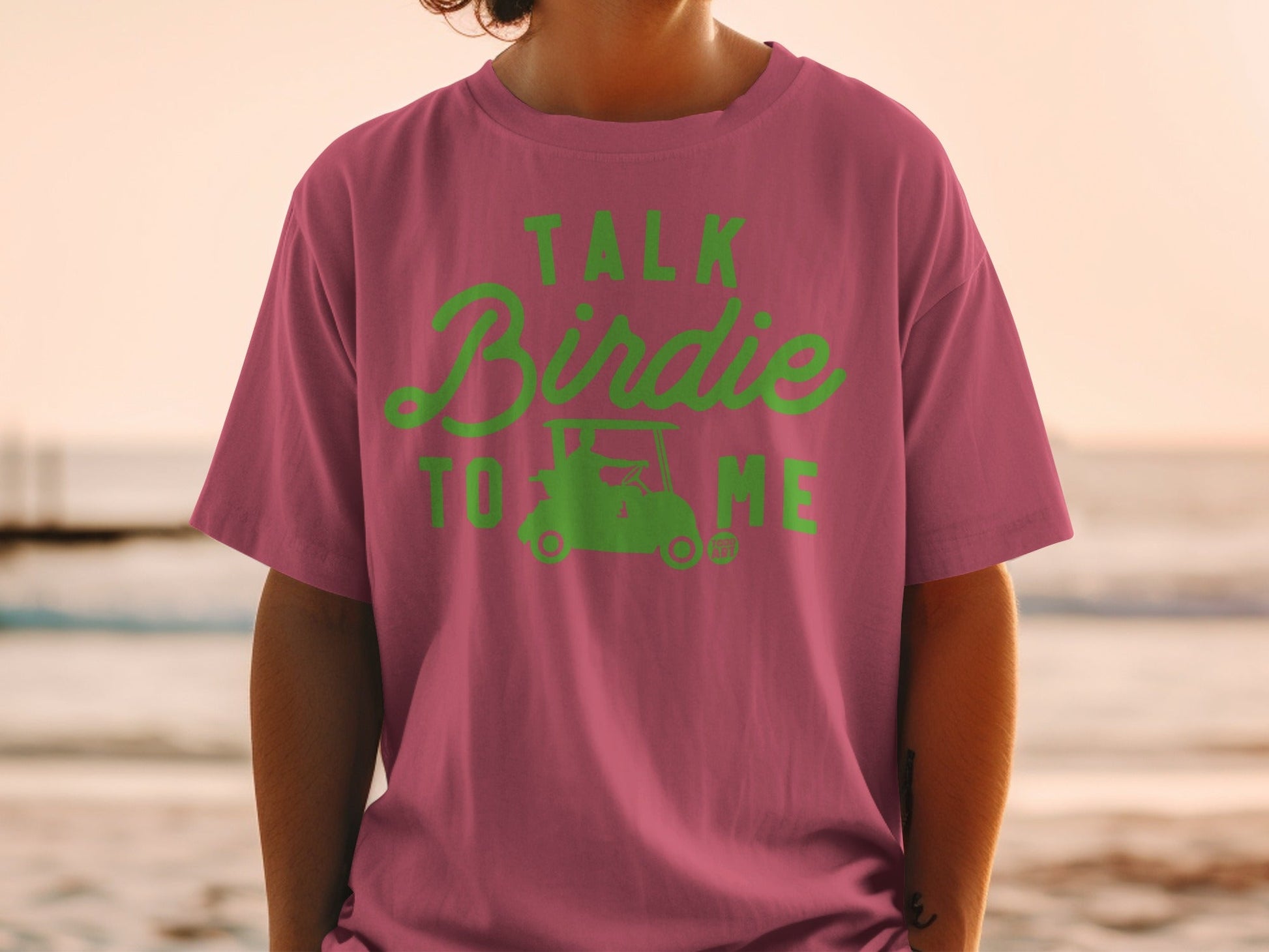 Pink t-shirt with "Talk Birdie to Me" text and golf cart graphic.