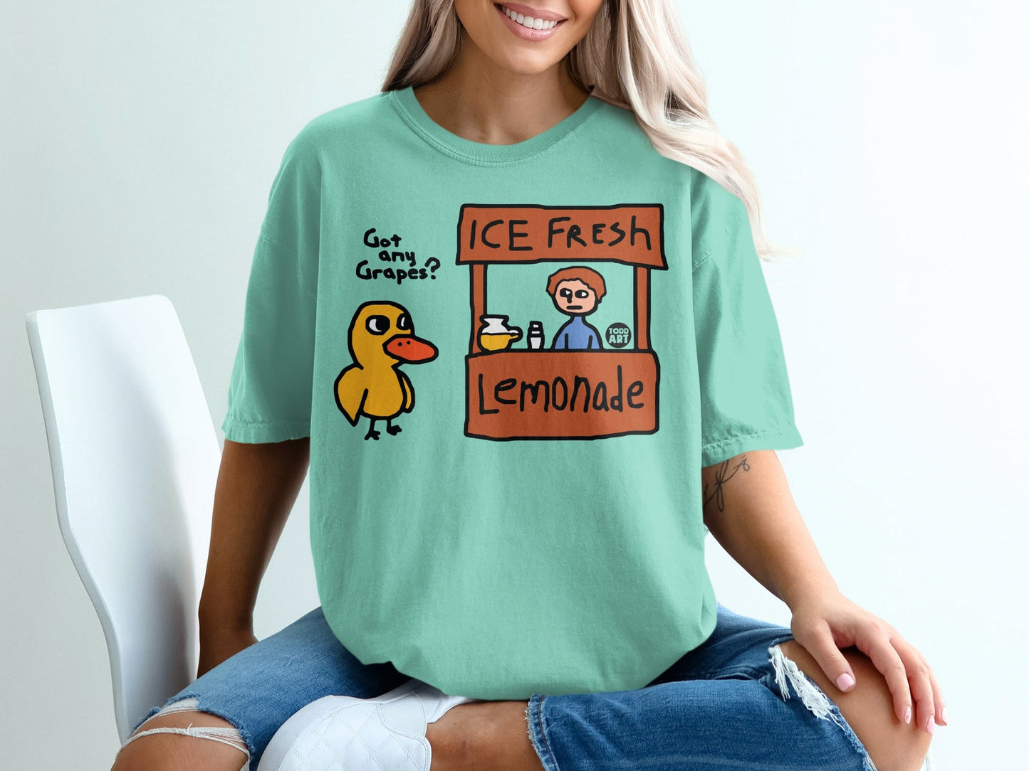 T-shirt with cartoon duck and lemonade stand graphic.