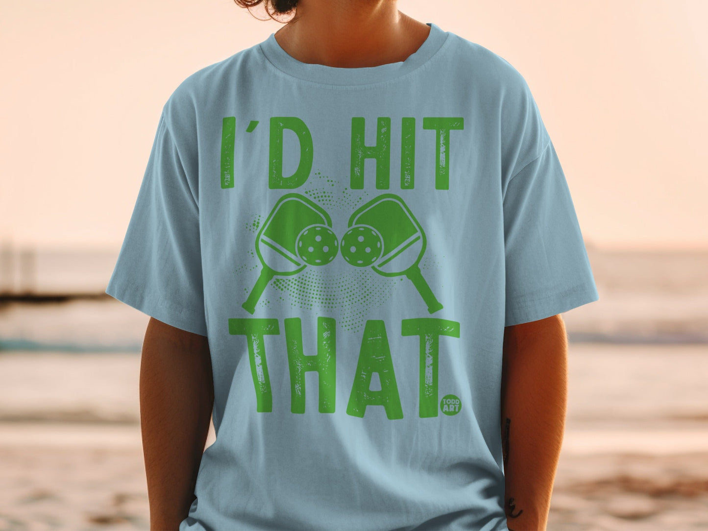 Light blue t-shirt with "I'D HIT THAT" and two pickleballs and paddles.