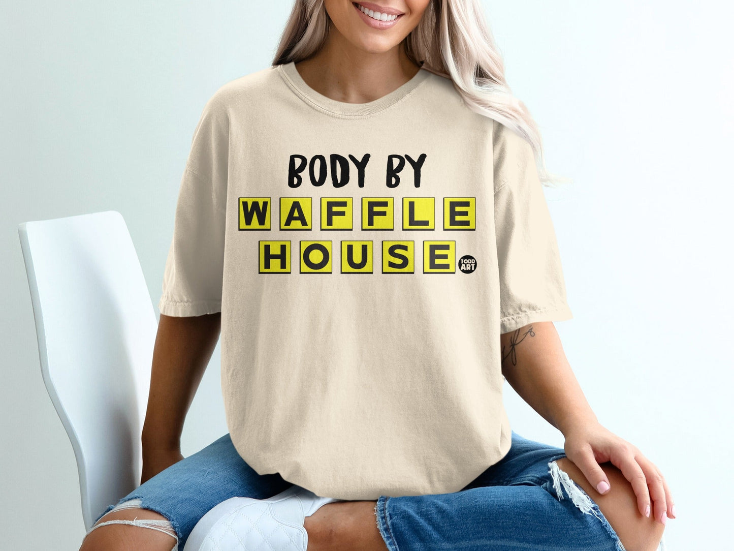 Cream t-shirt with "BODY BY WAFFLE HOUSE" text in yellow tile design.