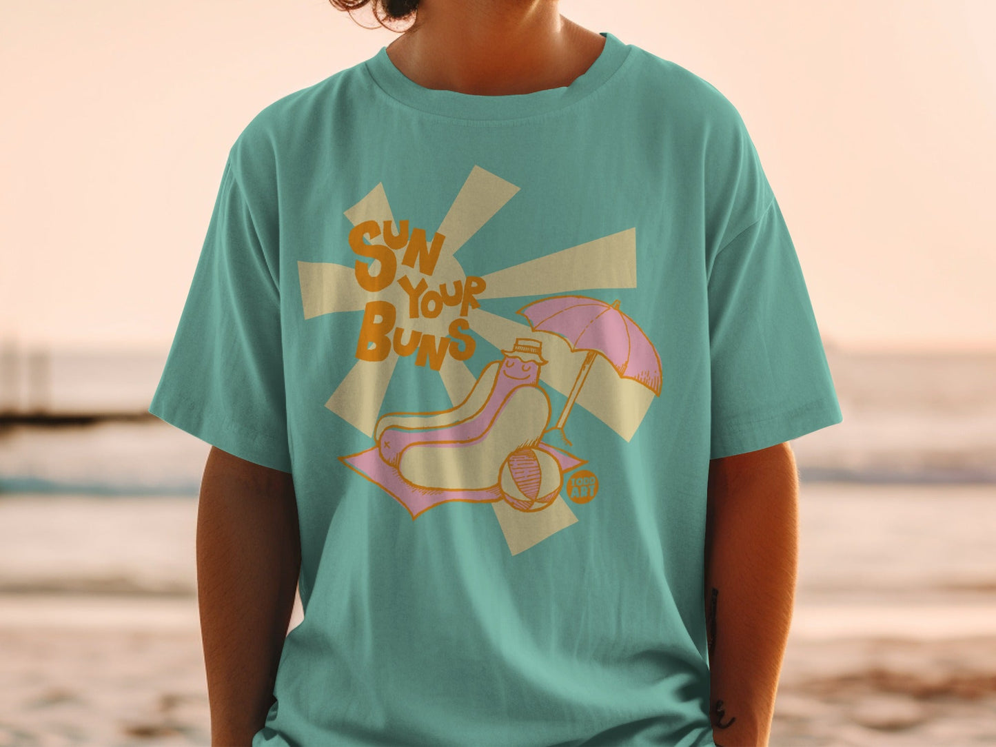 T-shirt with cartoon hot dog on beach, "sun your buns" text.
