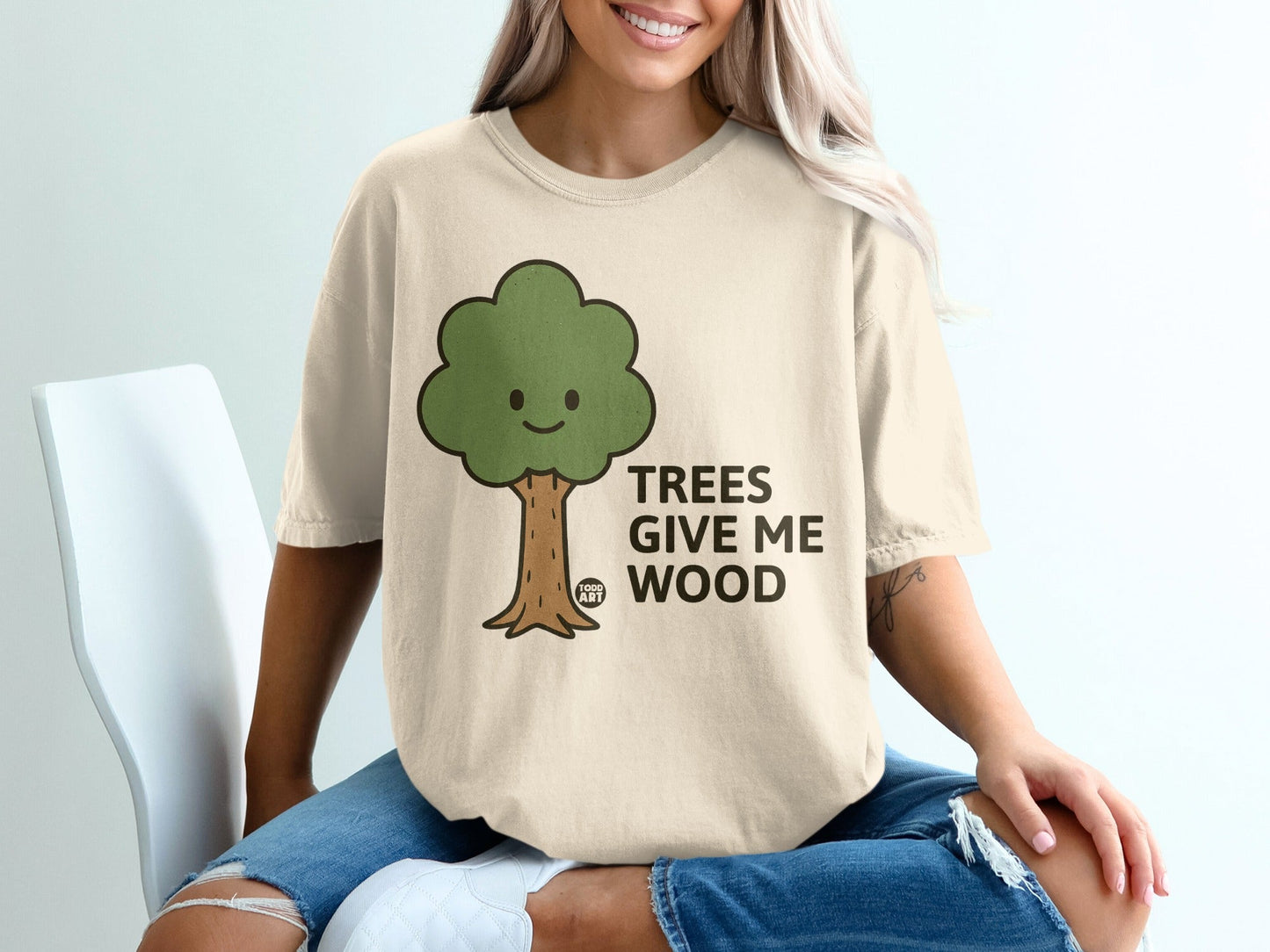 Cream t-shirt with cartoon tree graphic and text "TREES GIVE ME WOOD".