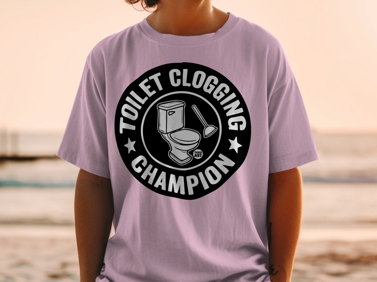 Toilet Clogging Champion circular logo on a purple t-shirt.
