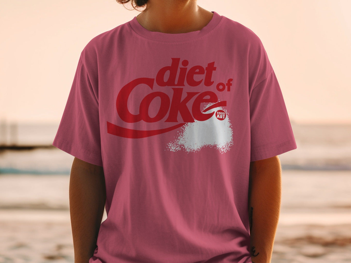 Diet Coke logo with spilled sugar granules on a pink t-shirt.