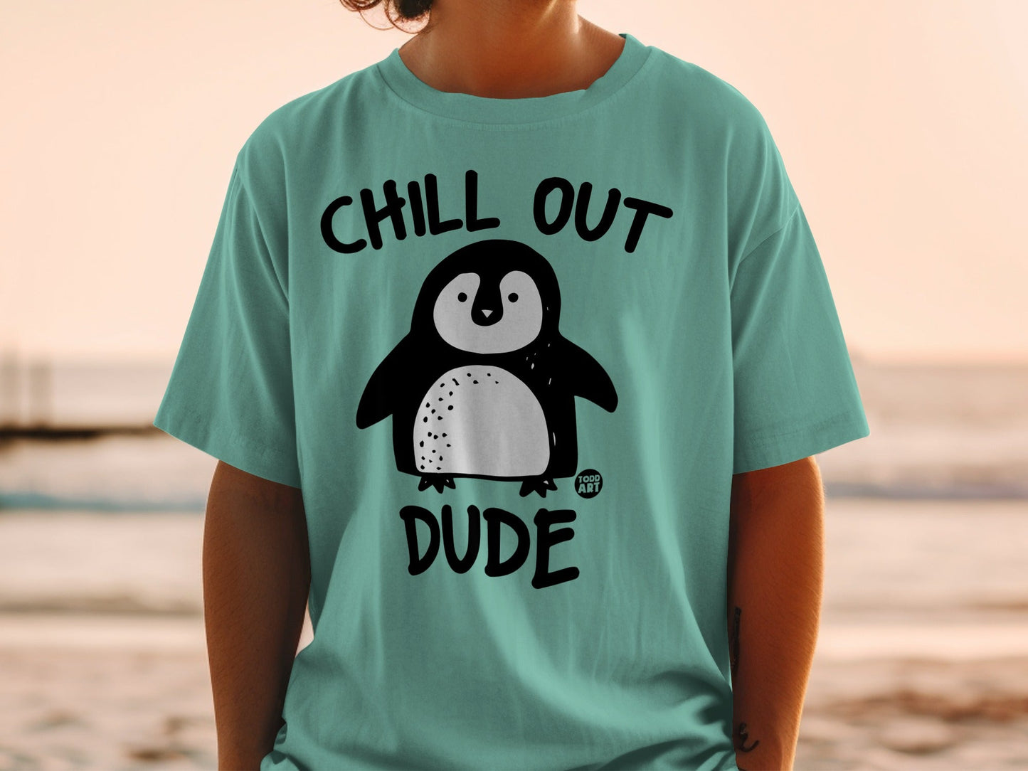 Teal t-shirt with a cartoon penguin and text "CHILL OUT DUDE".
