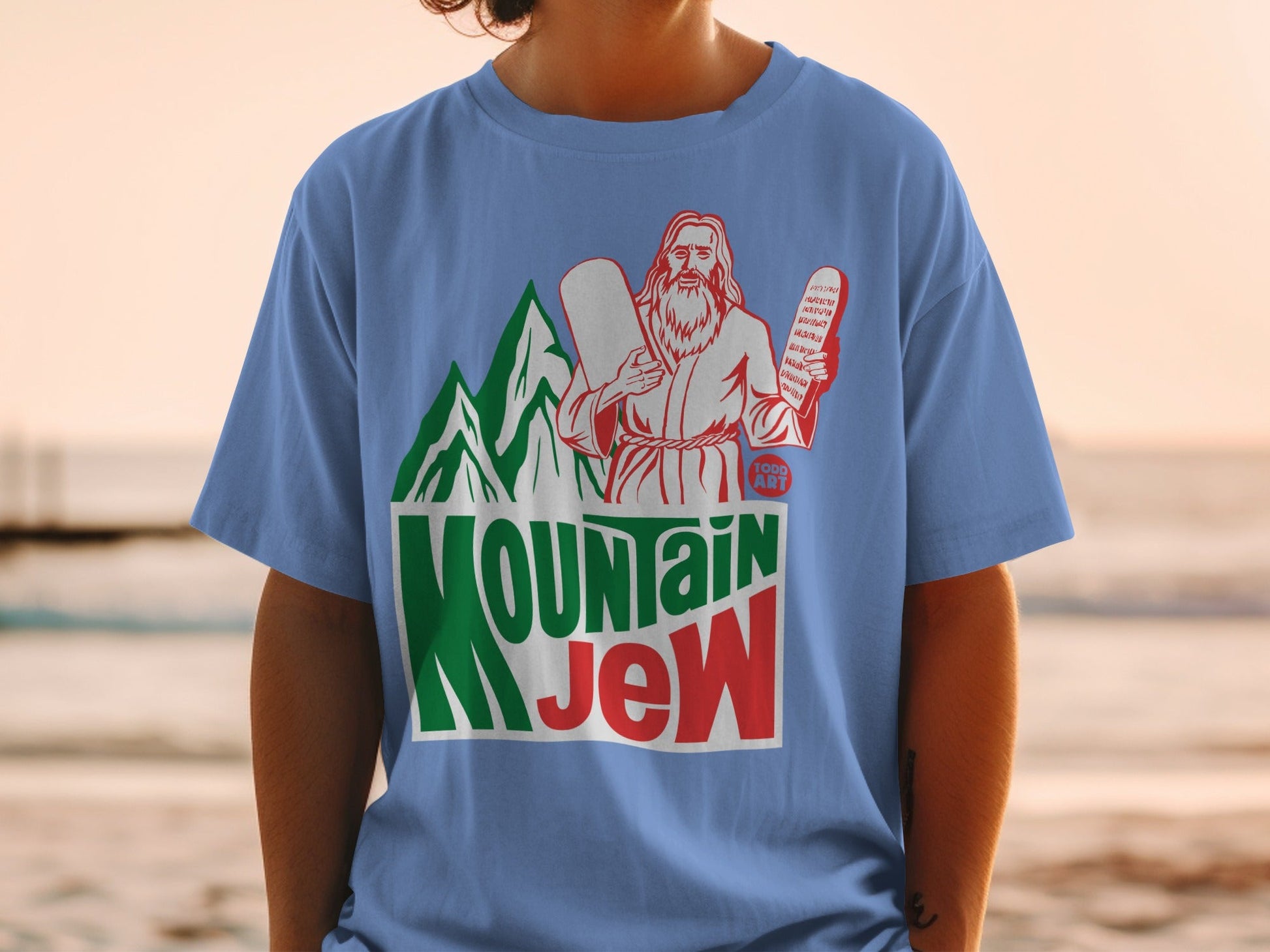 Jesus holding tablets with "Mountain Jew" text and green mountains.