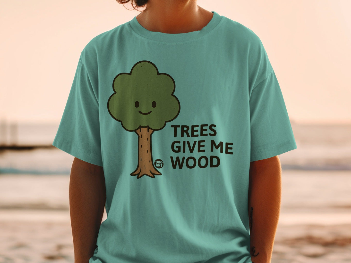 Teal t-shirt with a cartoon tree saying "TREES GIVE ME WOOD".