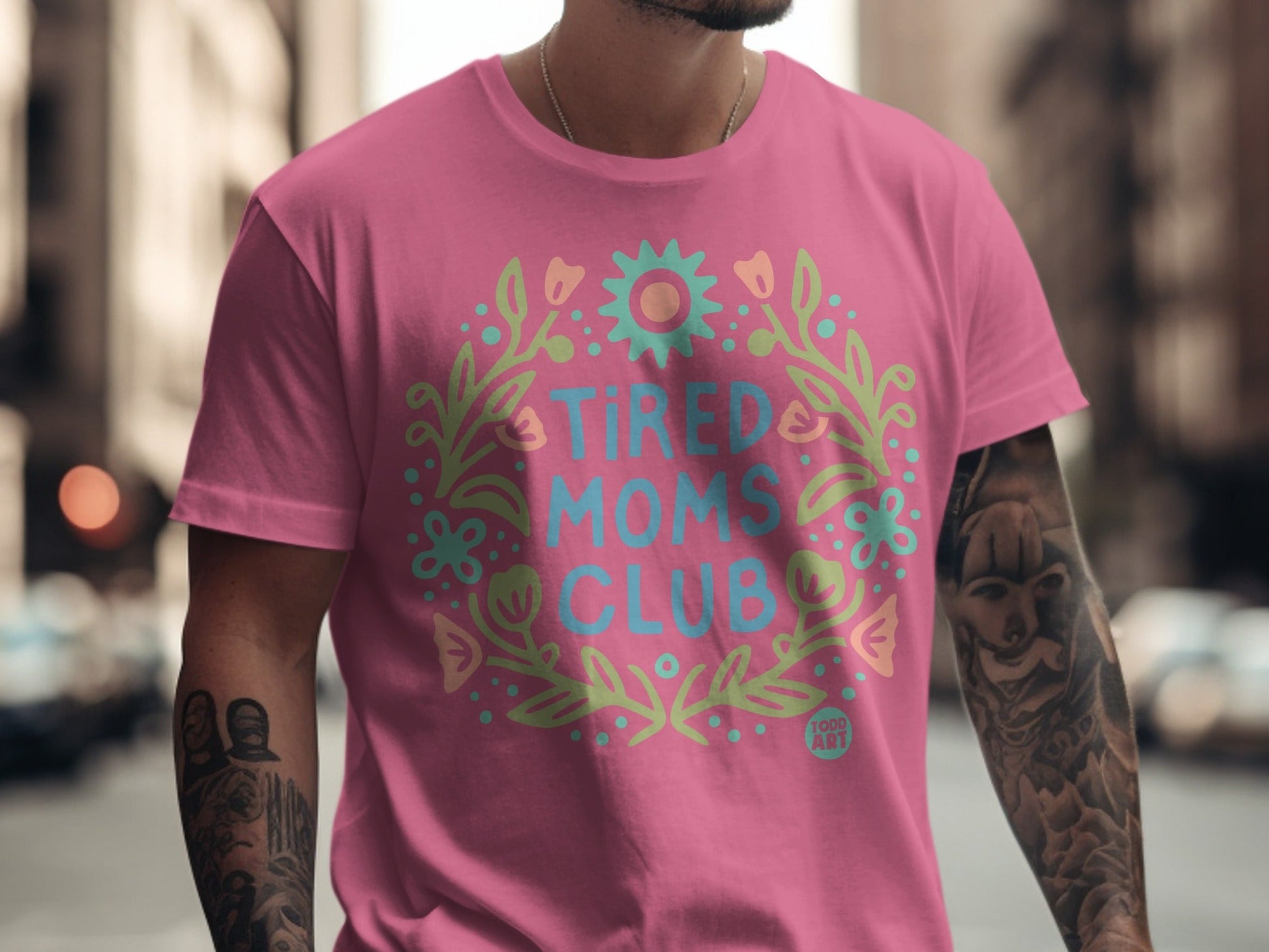Pink t-shirt with "Tired Moms Club" in floral wreath design.