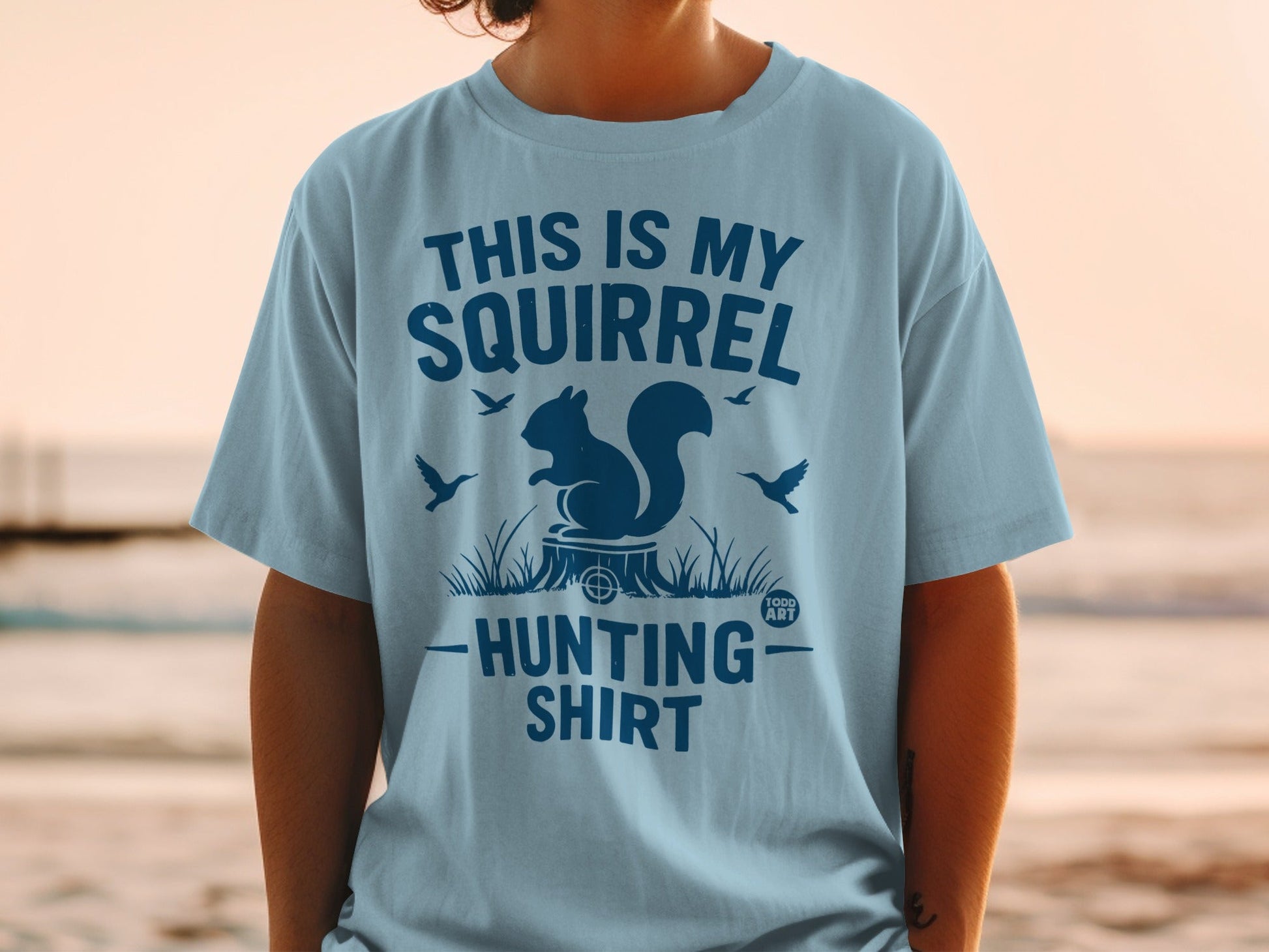Light blue t-shirt with "This is my squirrel hunting shirt" graphic.