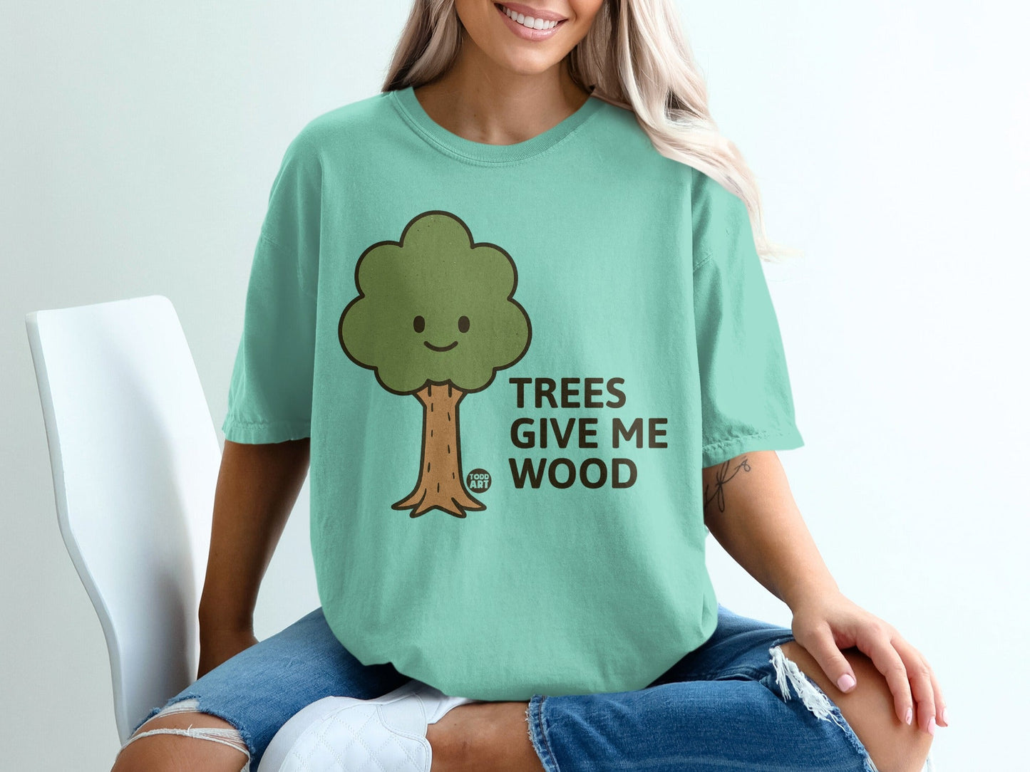 Green t-shirt with a cartoon tree and text "TREES GIVE ME WOOD".