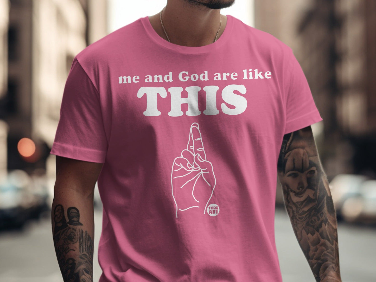 Pink t-shirt with white text "me and God are like THIS" and a hand gesture.
