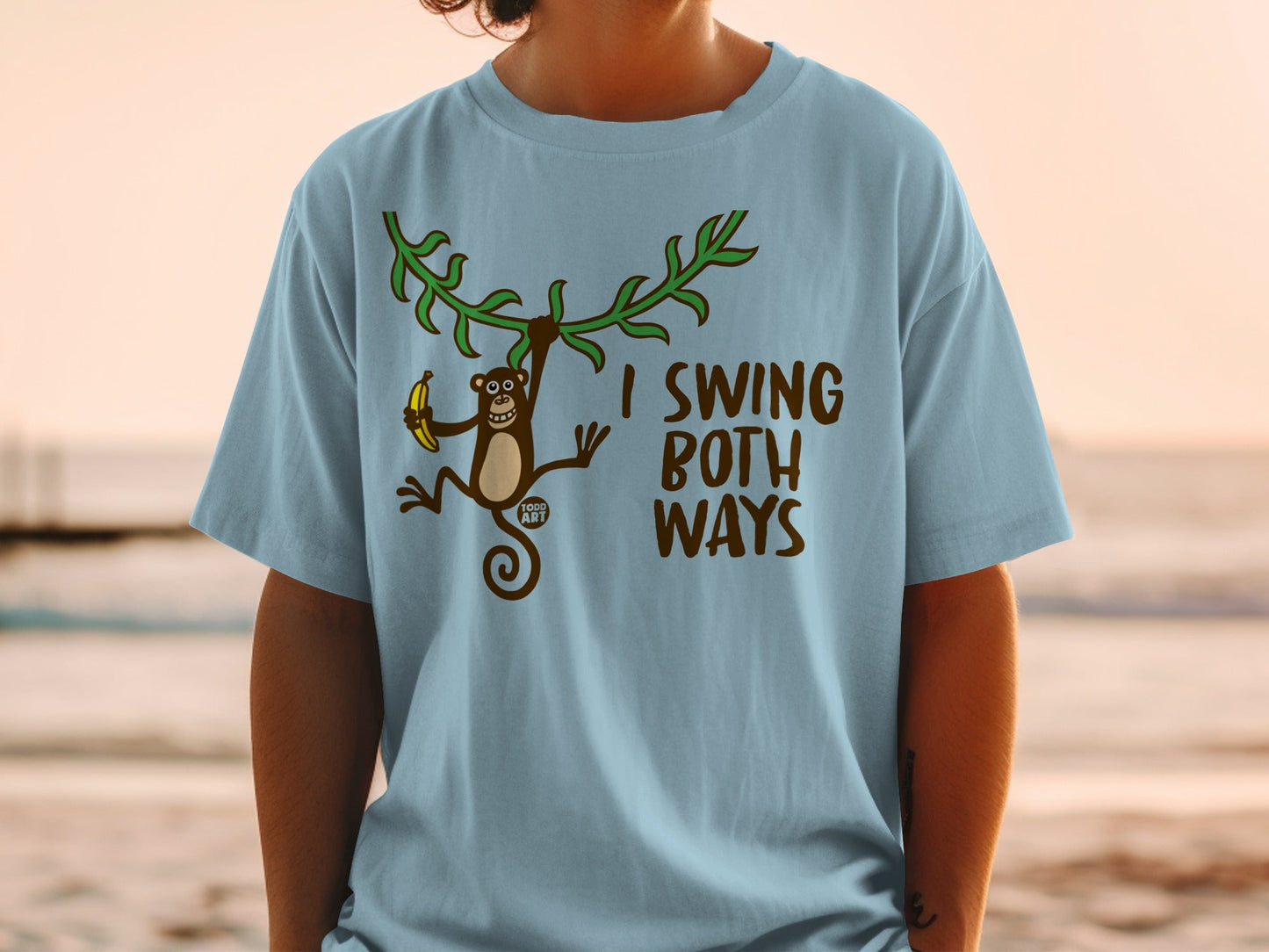 Light blue t-shirt with a cartoon monkey holding a banana and brown text.