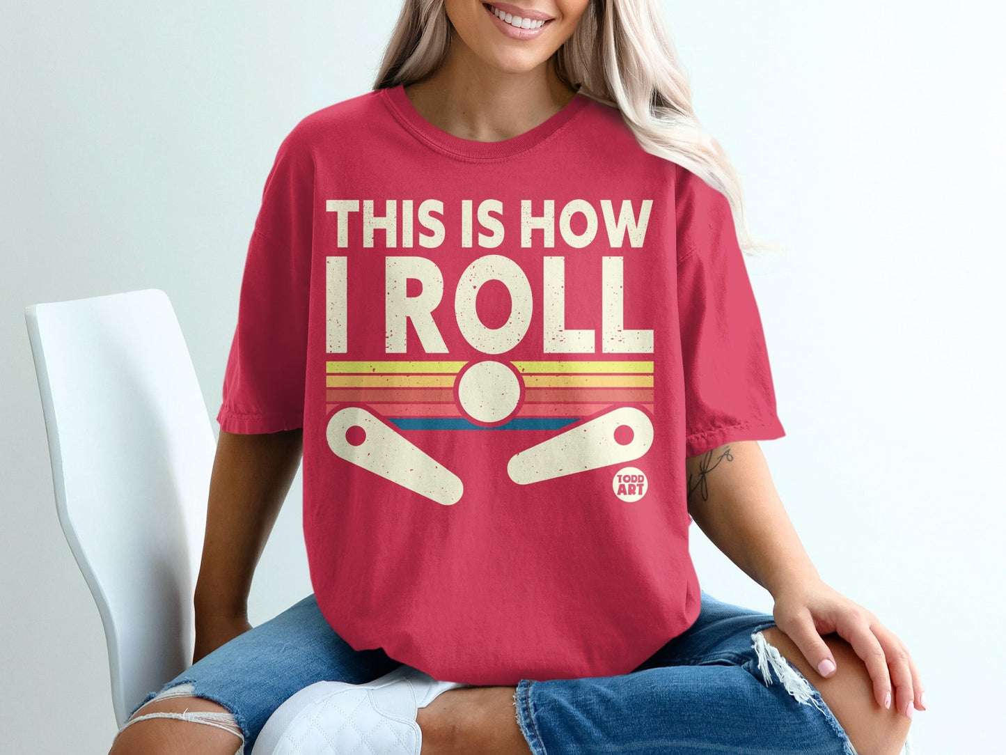 Woman wearing a red t-shirt with "THIS IS HOW I ROLL" and a pinball graphic.