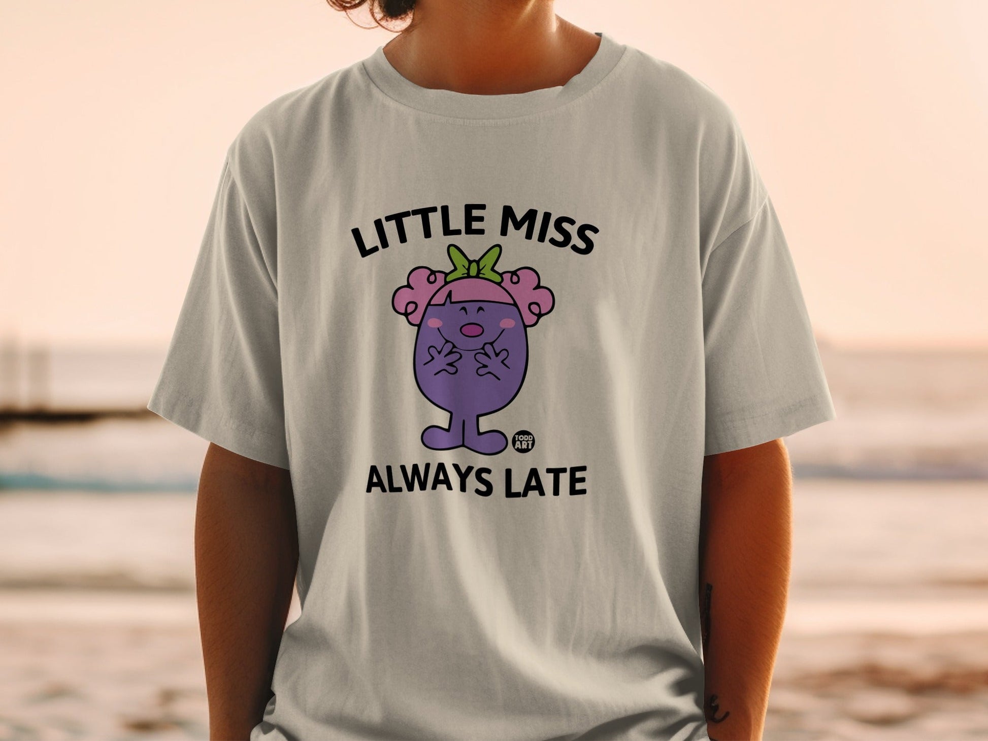 Little Miss Always Late character on a grey t-shirt.