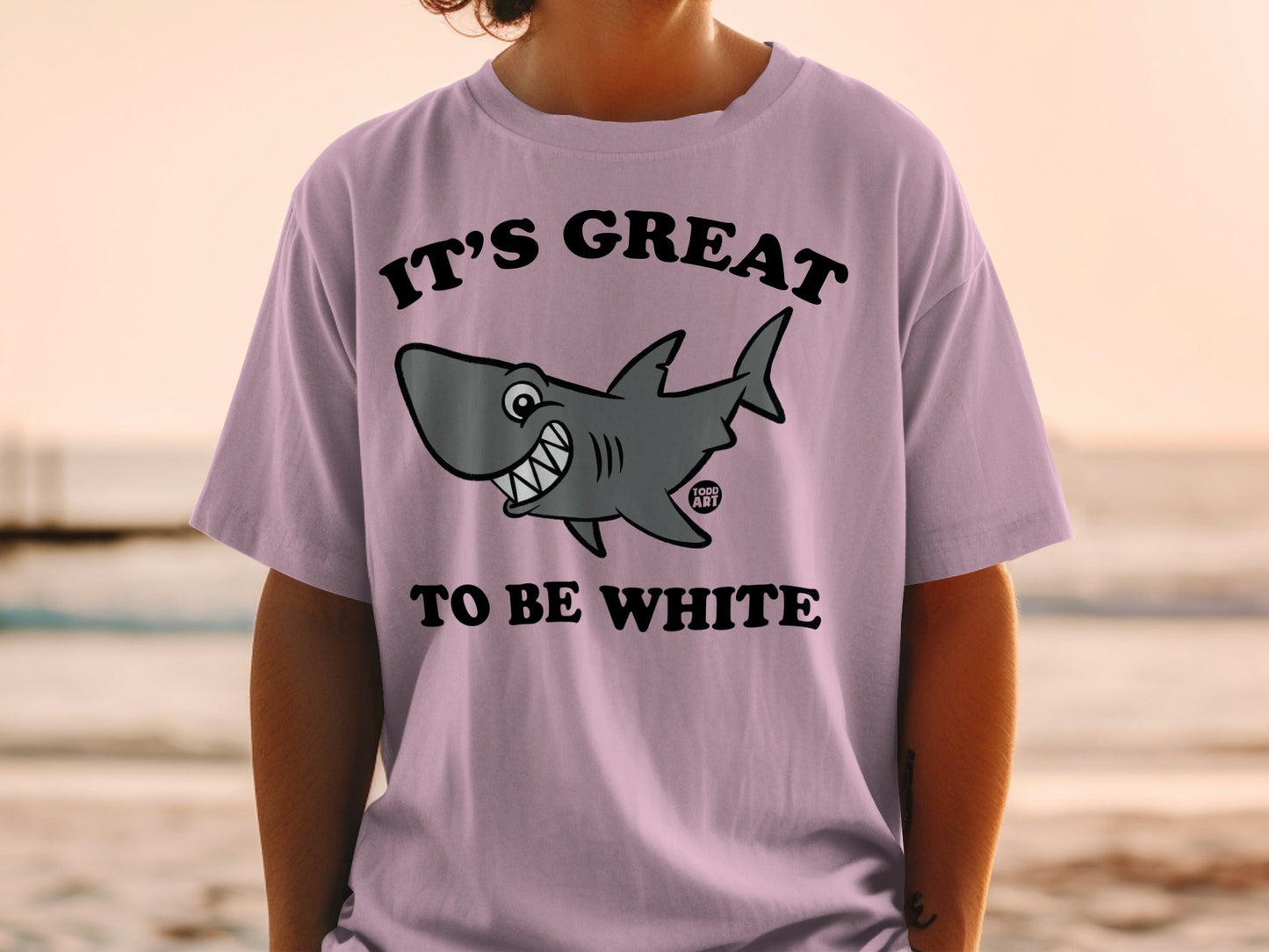 Pink t-shirt with a cartoon shark and text "IT'S GREAT TO BE WHITE".