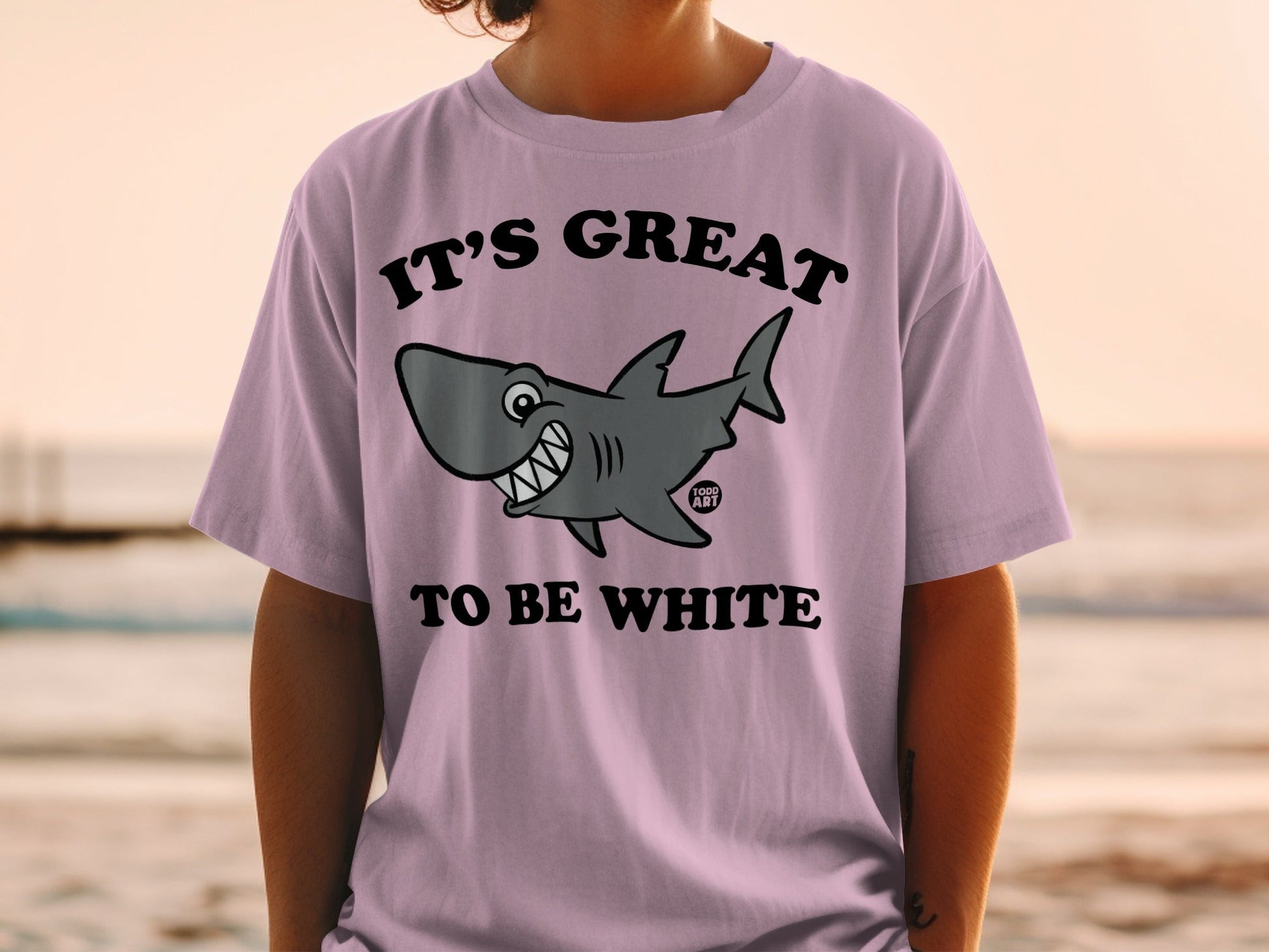 Pink t-shirt with a cartoon shark and text "IT'S GREAT TO BE WHITE".