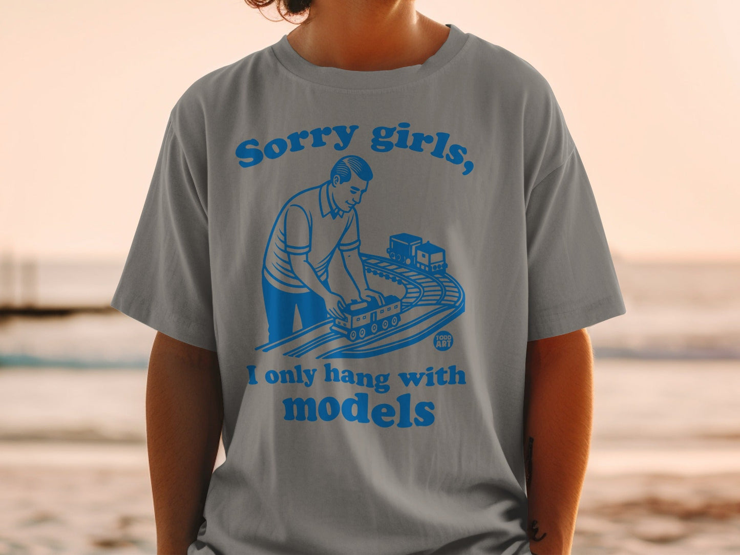 Gray t-shirt with blue text and illustration of a man with model trains.