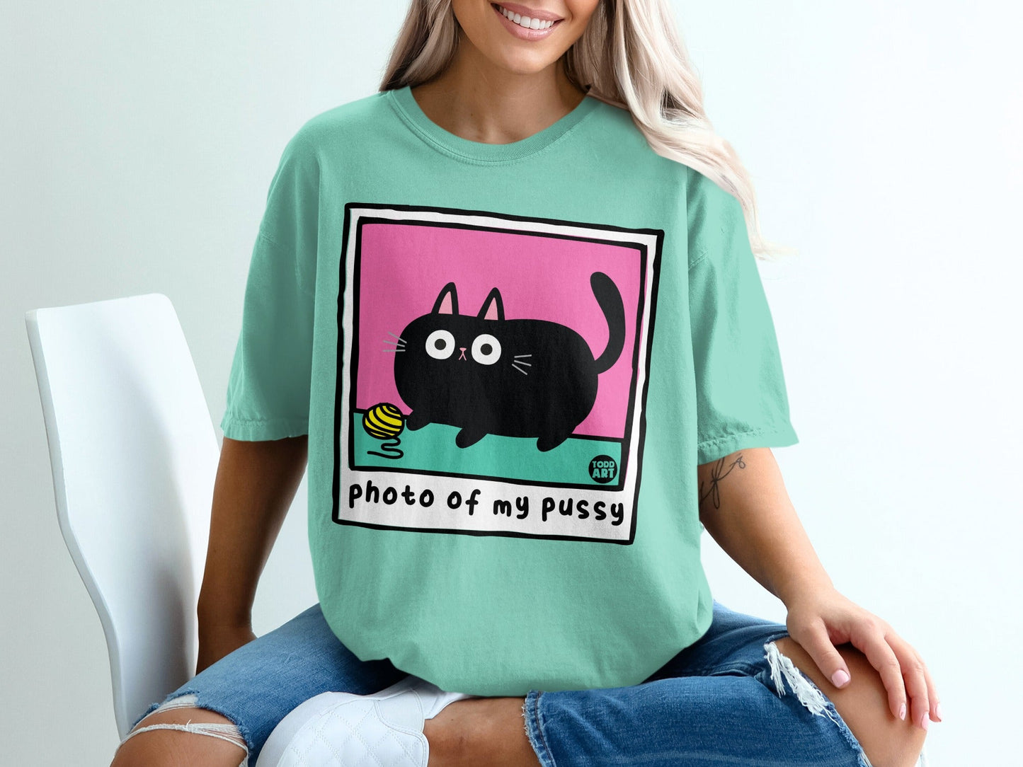 Teal t-shirt with cartoon black cat playing with yarn, text "photo of my pussy".