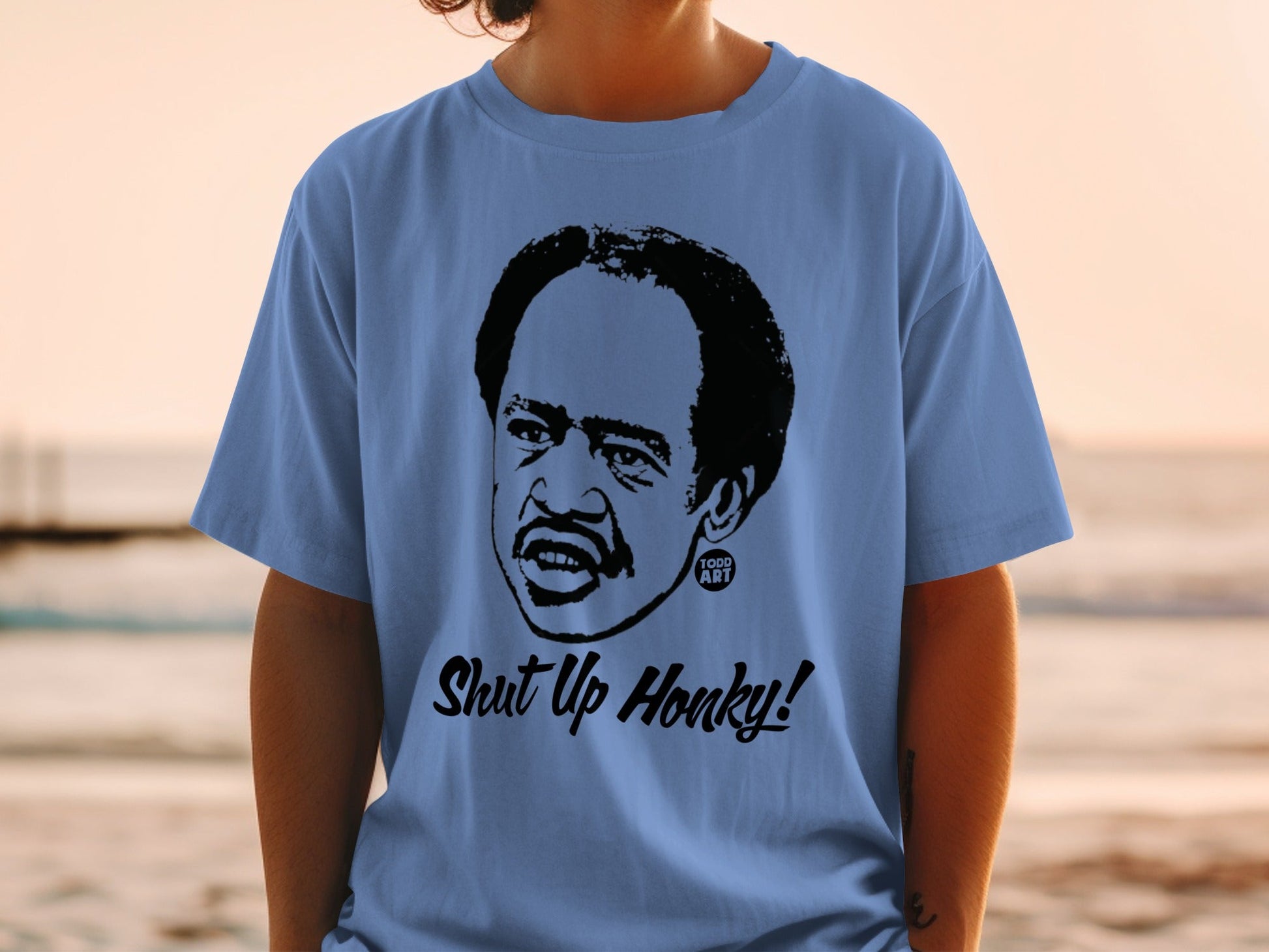 Blue t-shirt with black graphic of Richard Pryor saying "Shut Up Honky!".