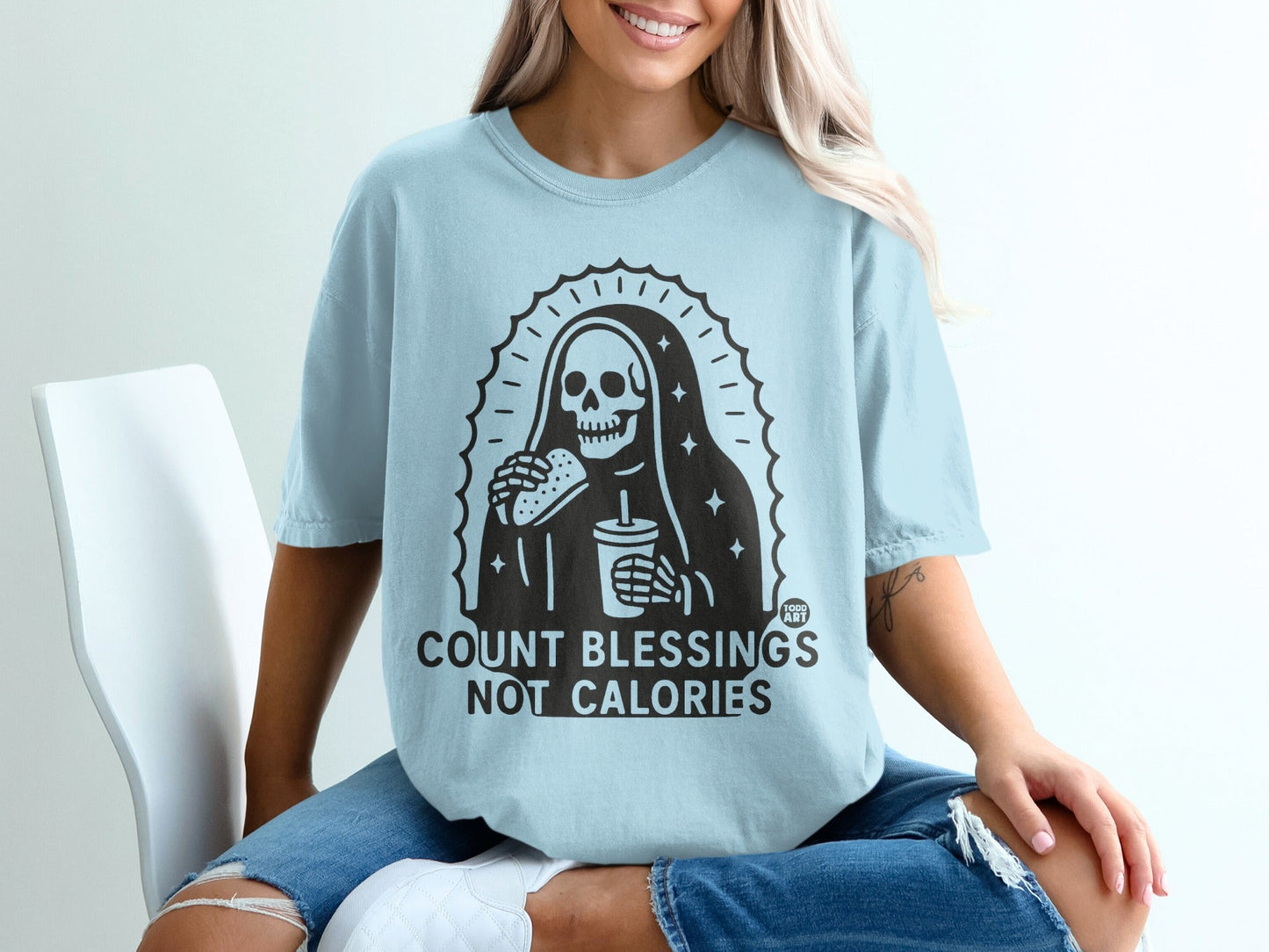 Light blue t-shirt with "COUNT BLESSINGS NOT CALORIES" text and grim reaper holding a drink and taco.