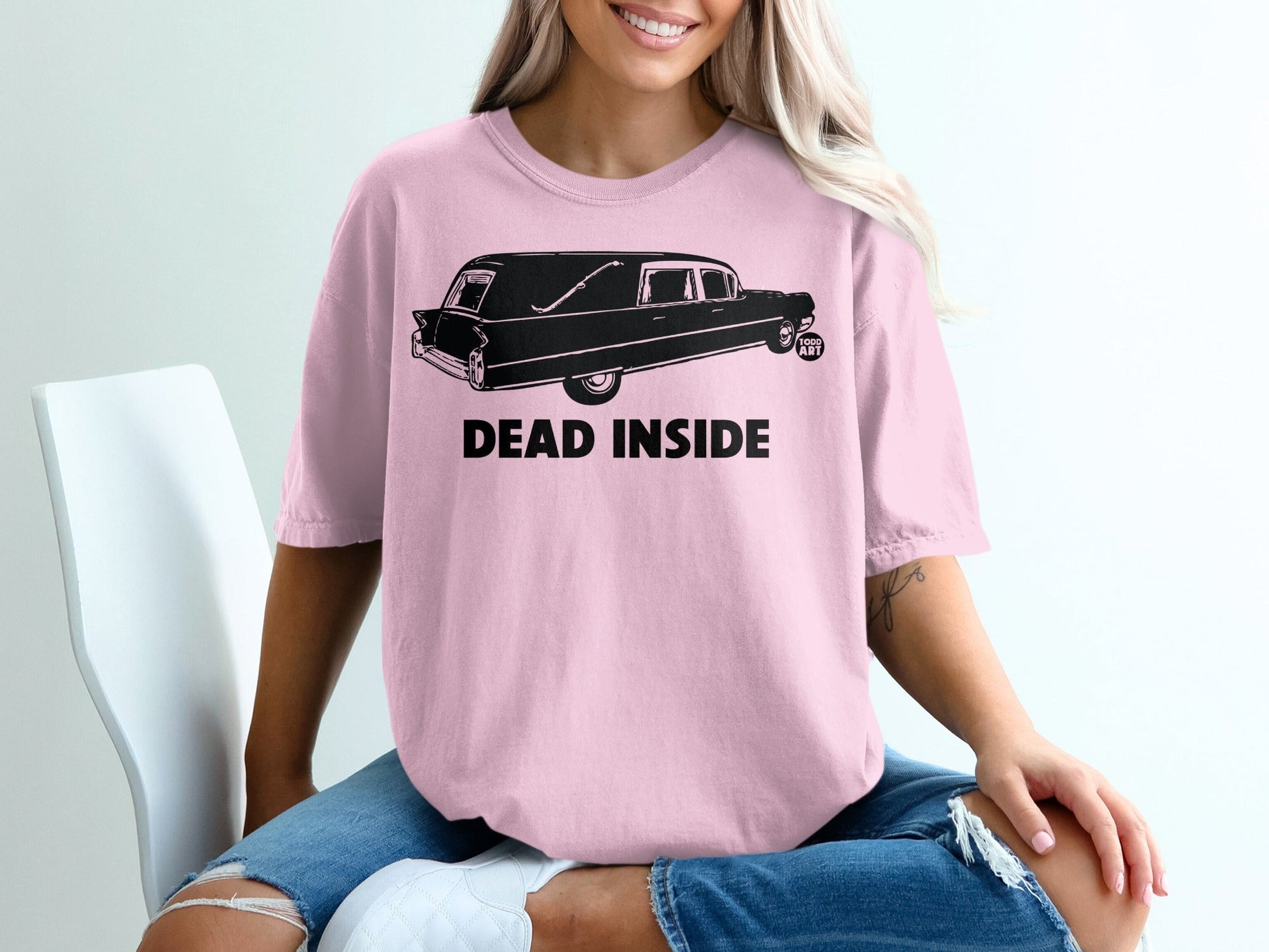 Pink t-shirt with "DEAD INSIDE" text and a hearse graphic.
