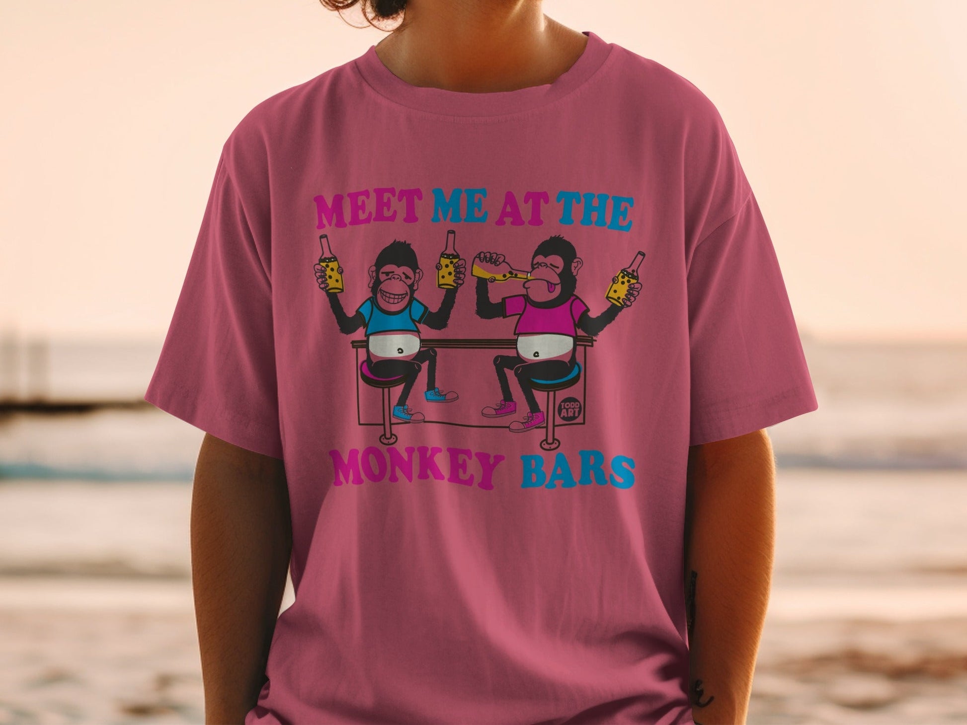 T-shirt with cartoon monkeys holding beer bottles and text "MEET ME AT THE MONKEY BARS".
