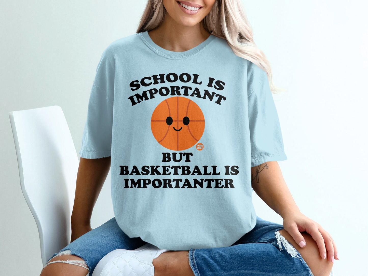 Light blue t-shirt with text "School is important but basketball is importanter" and a basketball graphic.