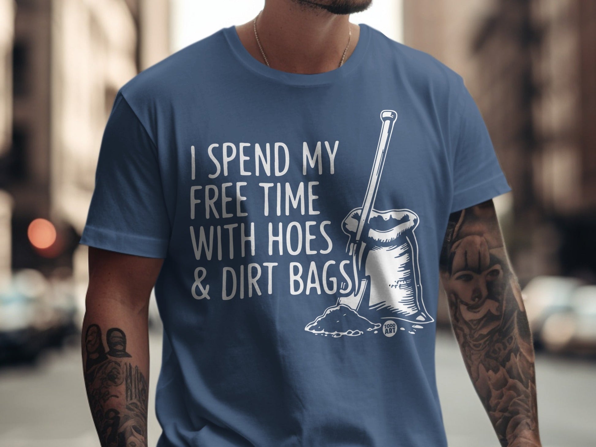 Blue t-shirt with "I spend my free time with hoes & dirt bags" and shovel graphic.