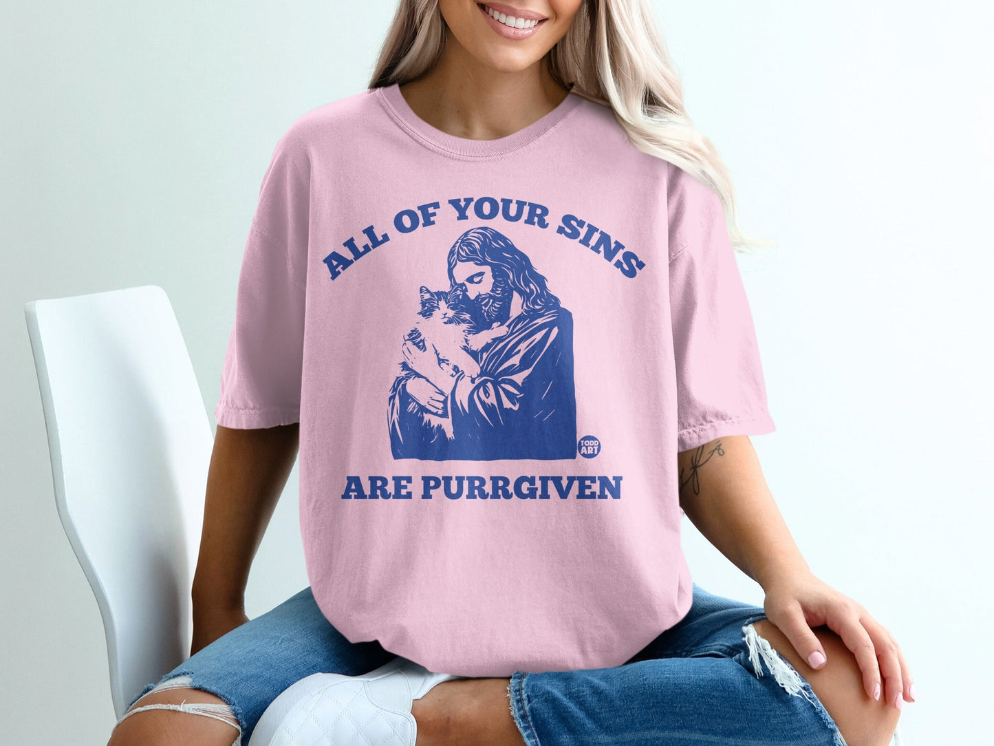 Pink t-shirt with "ALL OF YOUR SINS ARE PURRGIVEN" text and Jesus holding a cat.