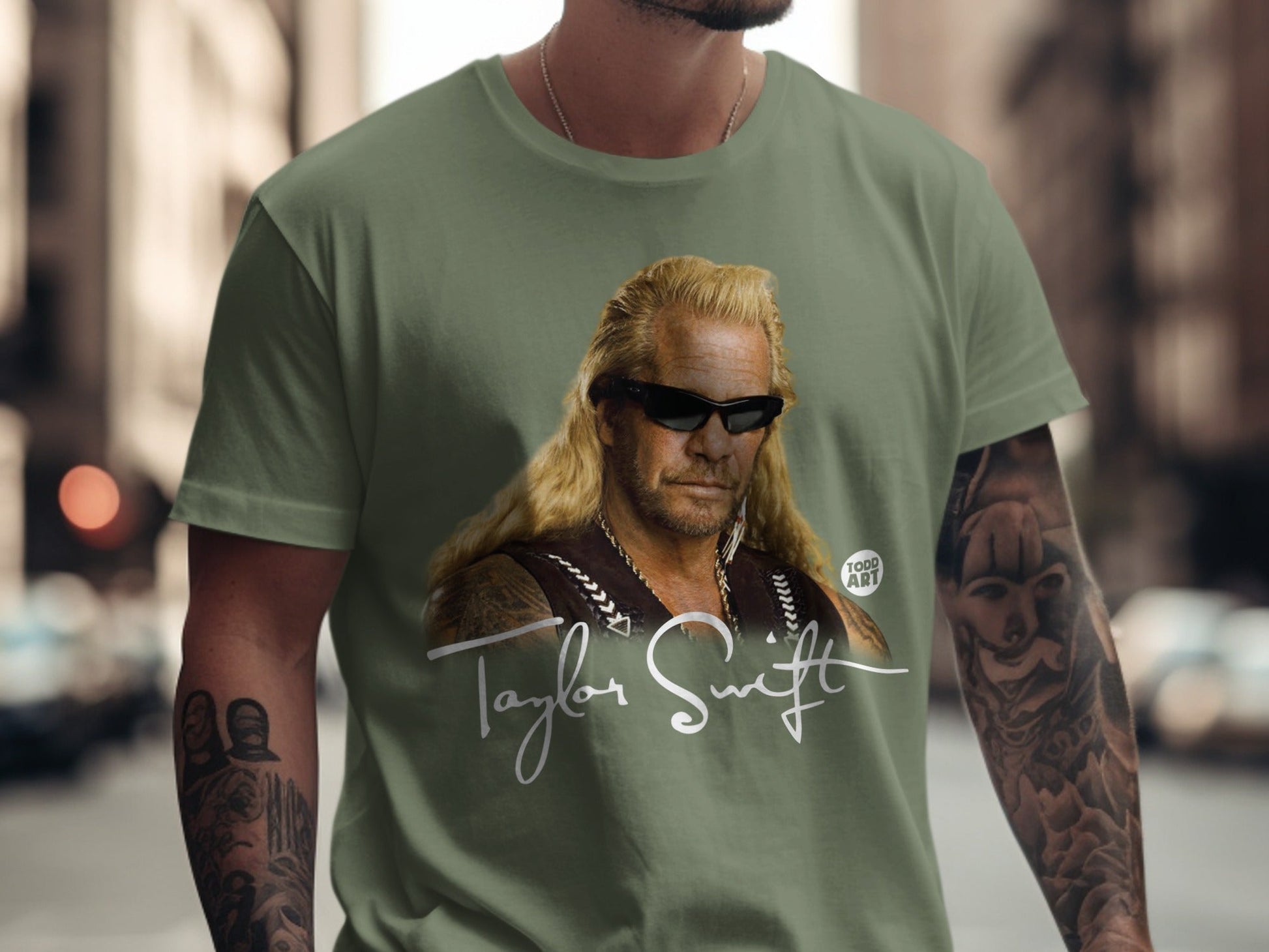 Dog the Bounty Hunter wearing a green t-shirt with his portrait.