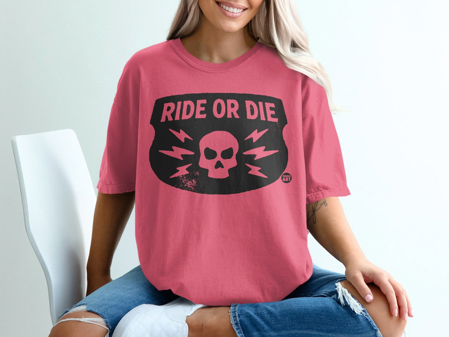 Pink t-shirt with black "Ride or Die" skull and lightning bolt graphic.