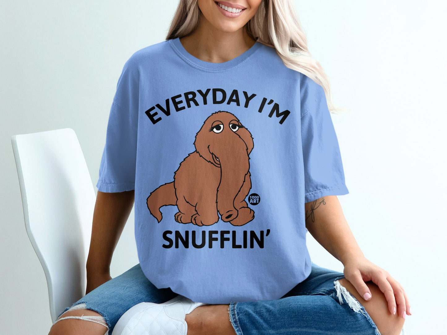 Light blue t-shirt with "EVERYDAY I'M SNUFFLIN'" text and a brown cartoon creature.