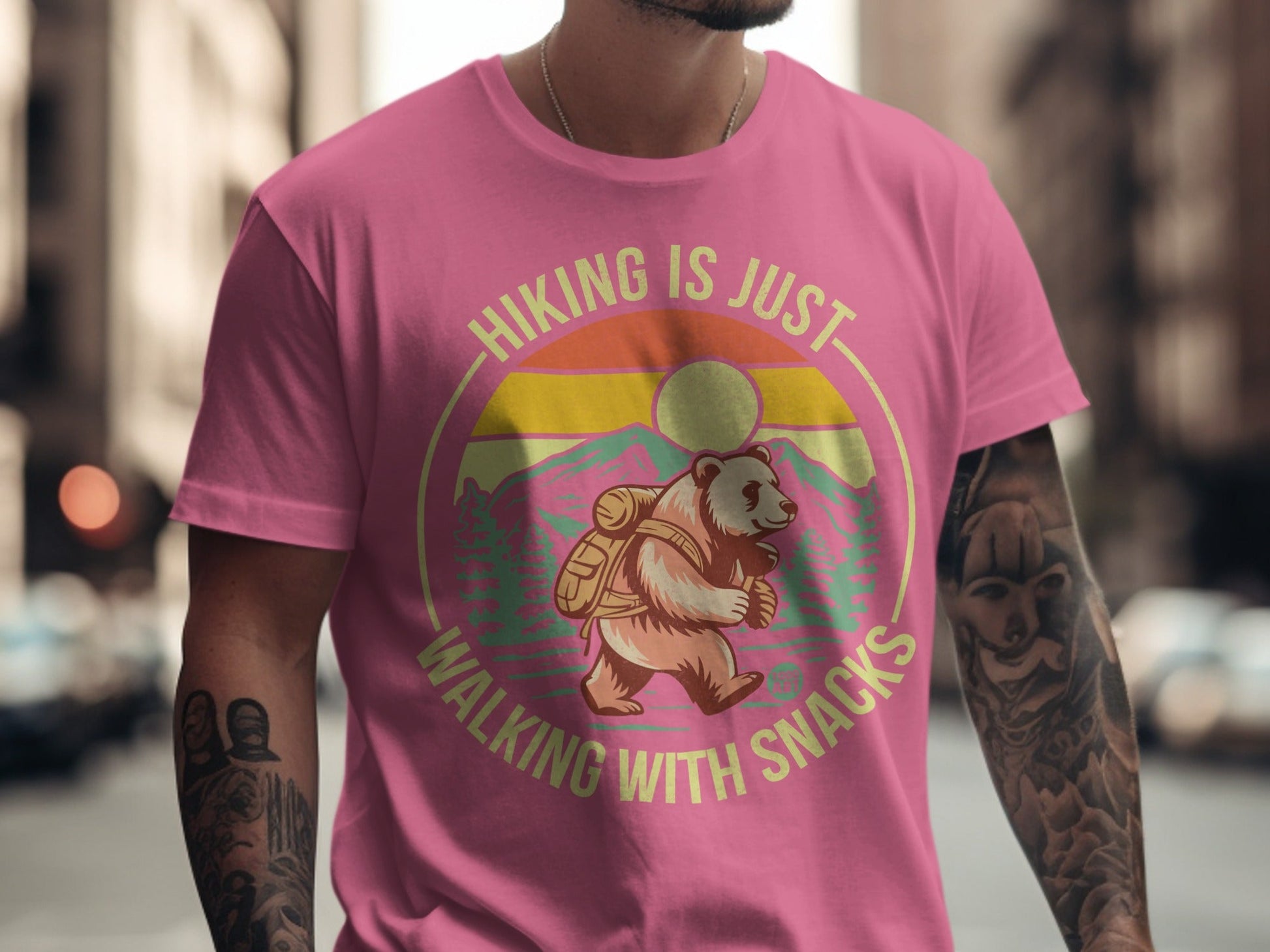 Pink t-shirt with graphic of a bear hiking, reading "Hiking is just walking with snacks."