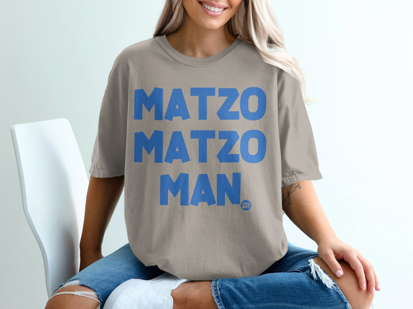 Tan t-shirt with large blue "MATZO MATZO MAN" text and small "GOOD ART" logo.