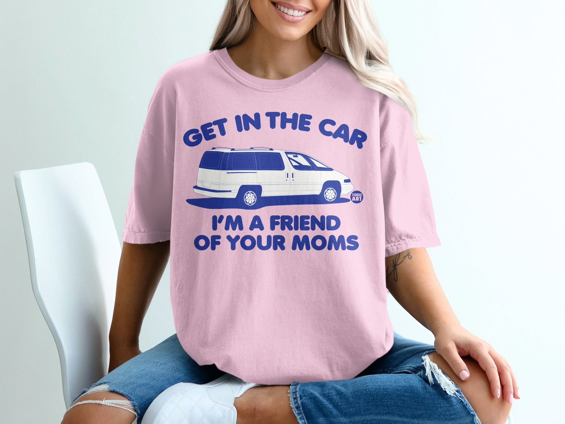Pink t-shirt with blue text "GET IN THE CAR I'M A FRIEND OF YOUR MOMS" and a graphic of a van.
