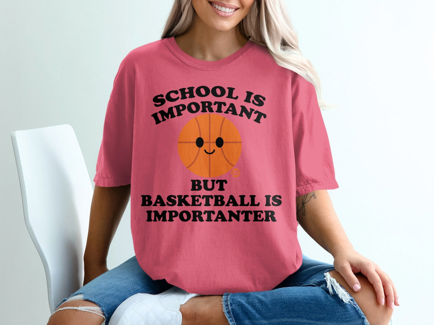 Pink t-shirt with a cartoon basketball saying "School is important but basketball is importanter".