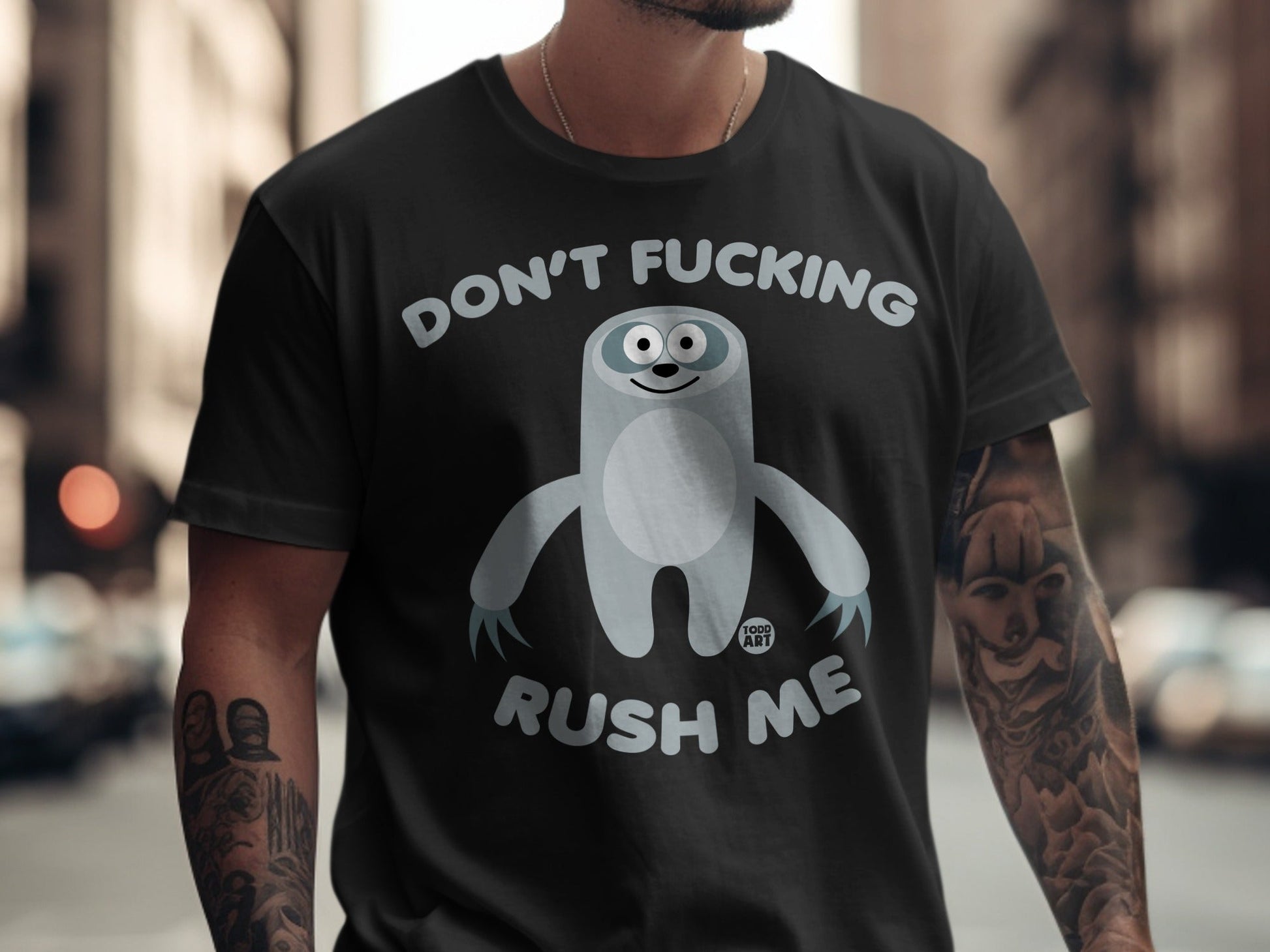 Black t-shirt with a cartoon sloth and text "DON'T FUCKING RUSH ME".
