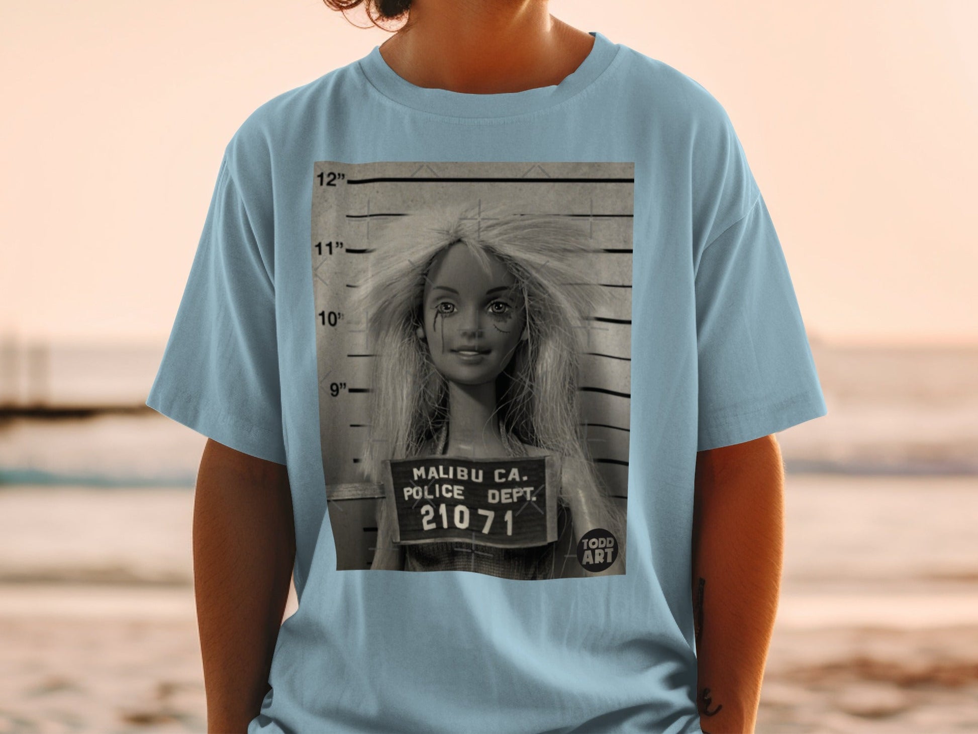 Barbie mugshot with "Malibu Ca. Police Dept. 21071 Todd Art" text.