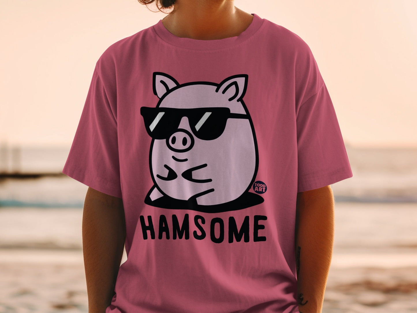 Pink t-shirt with cartoon pig wearing sunglasses and text "HAMSOME"
