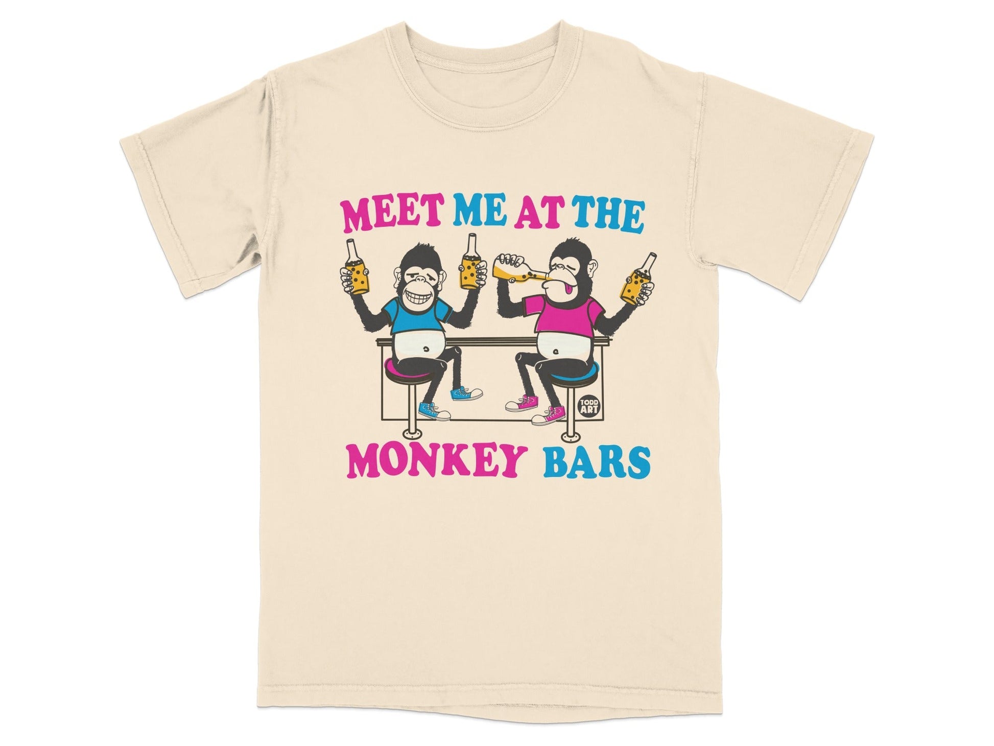 Cream t-shirt with cartoon monkeys toasting drinks, text "MEET ME AT THE MONKEY BARS".