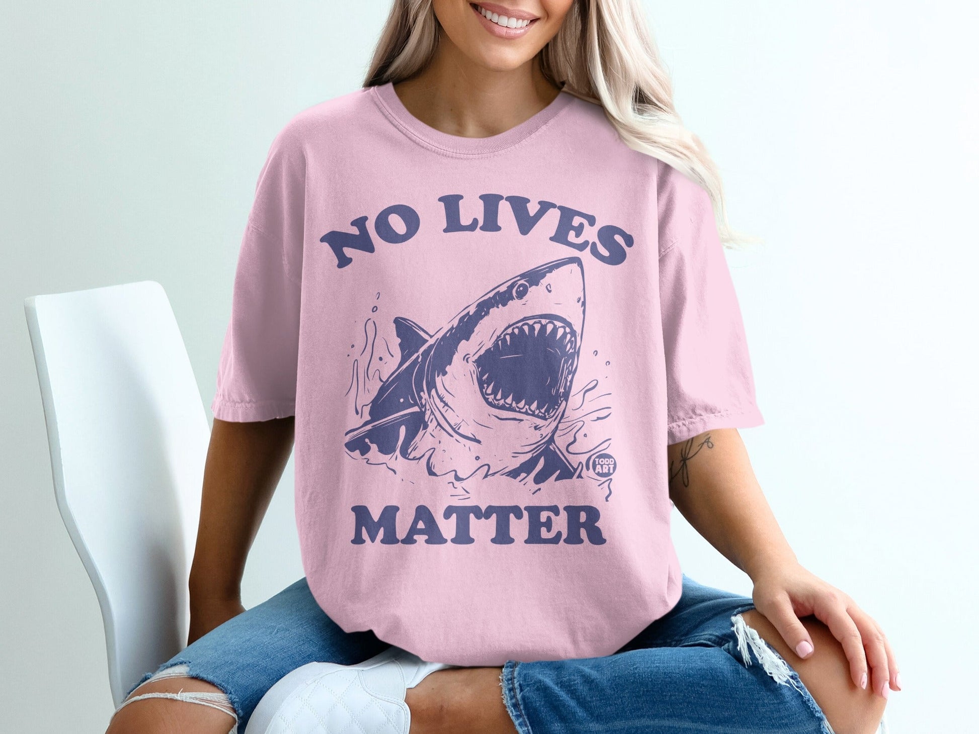 Pink t-shirt with distressed shark graphic and "No Lives Matter" text.