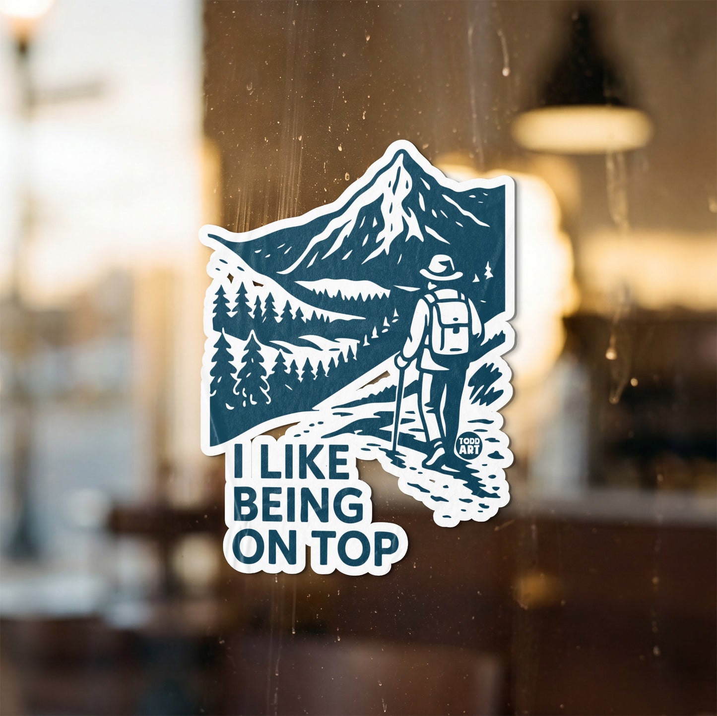 Blue and white sticker with hiker on mountain trail, "I Like Being On Top" text.