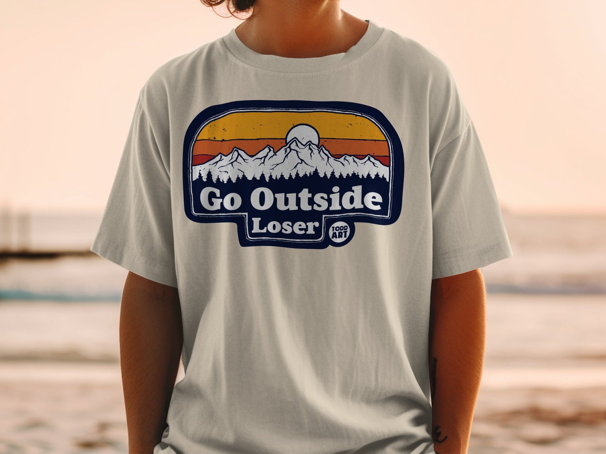 Gray t-shirt with "Go Outside Loser" text and mountain sunset graphic.