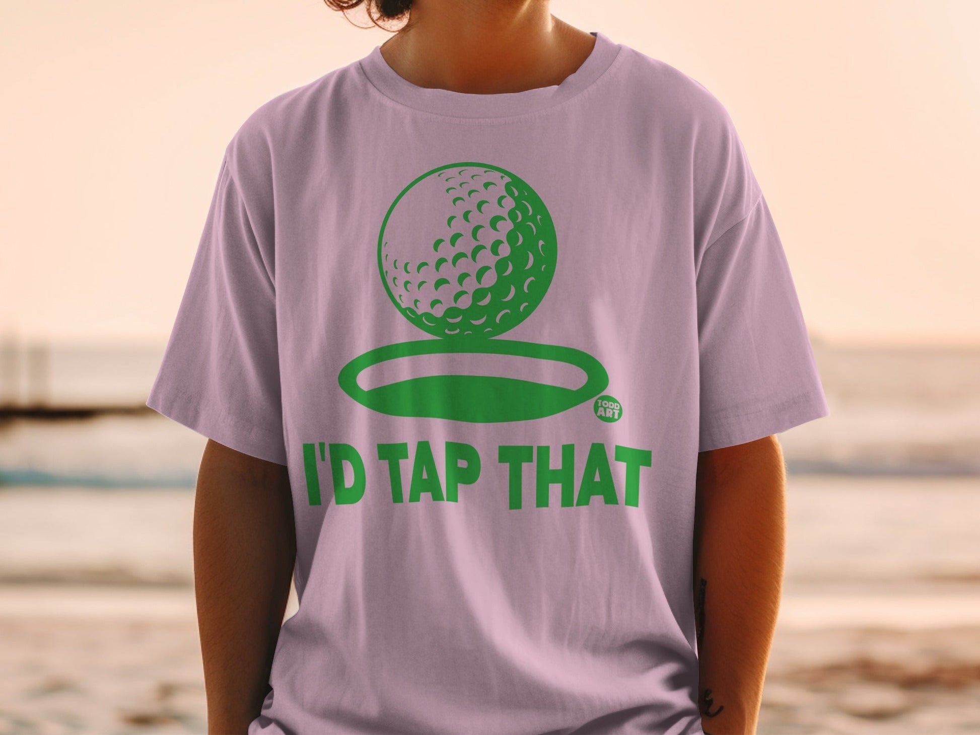 Light purple t-shirt with green golf ball and "I'd Tap That" text.